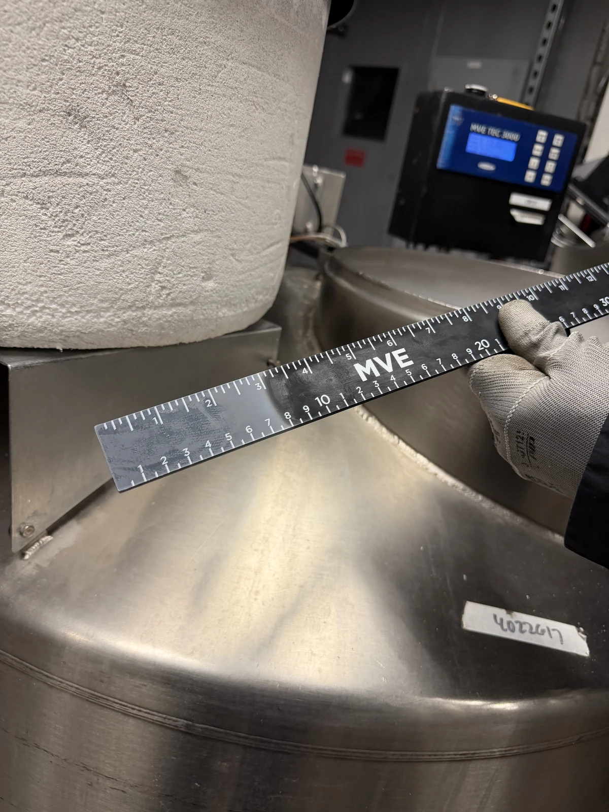 Technician measuring frost buildup on a cryogenic tank