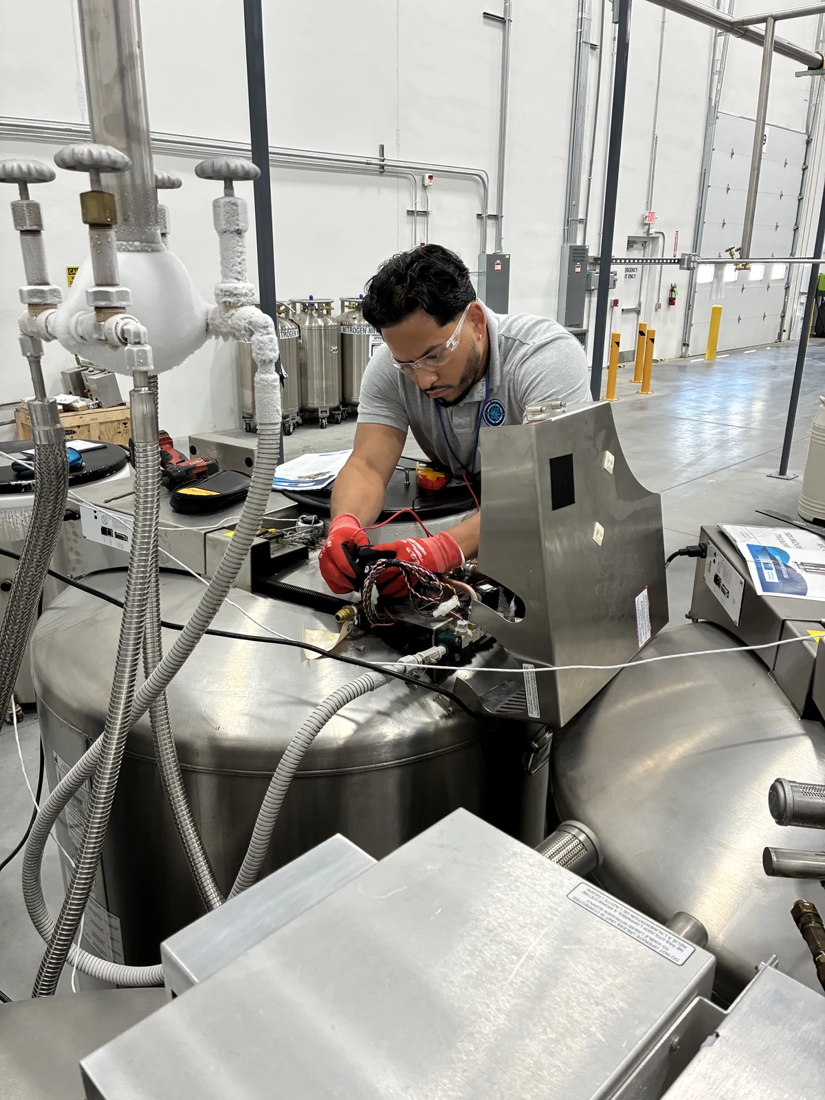 Technician servicing electrical components on a cryogenic tank